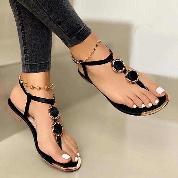 Women's black thong flat sandals pair for summer beach with circular stone embellishments and gold-tone accents
