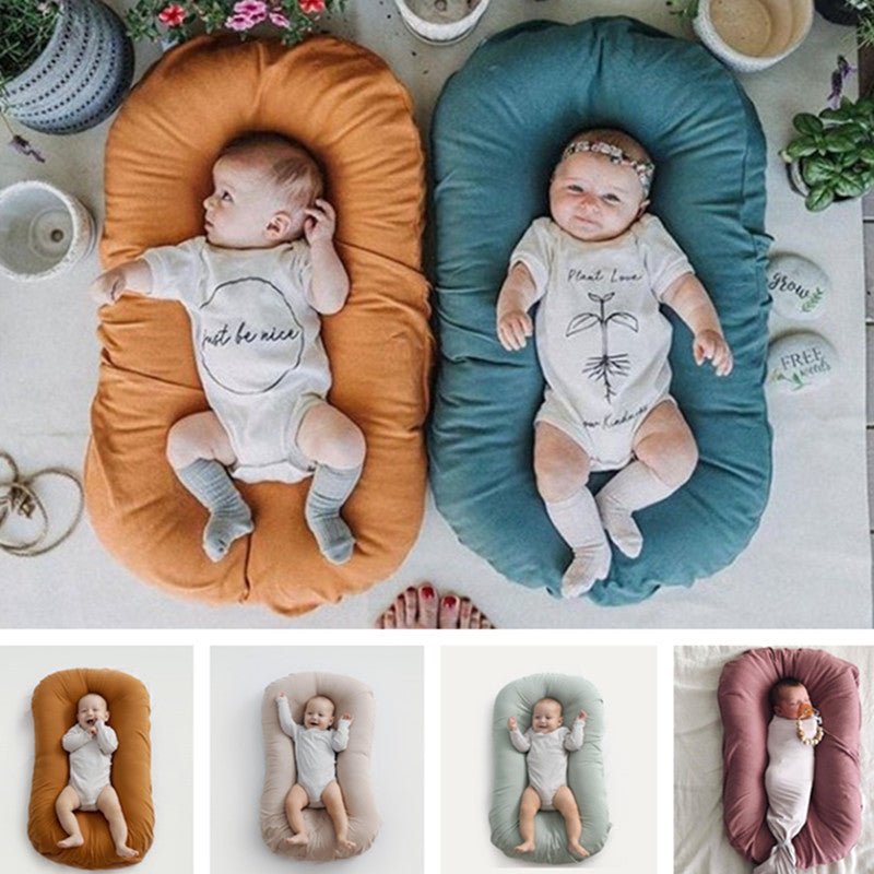 Two baby nest beds in orange and teal with newborns, portable cotton travel cradles by Ancient Energy.