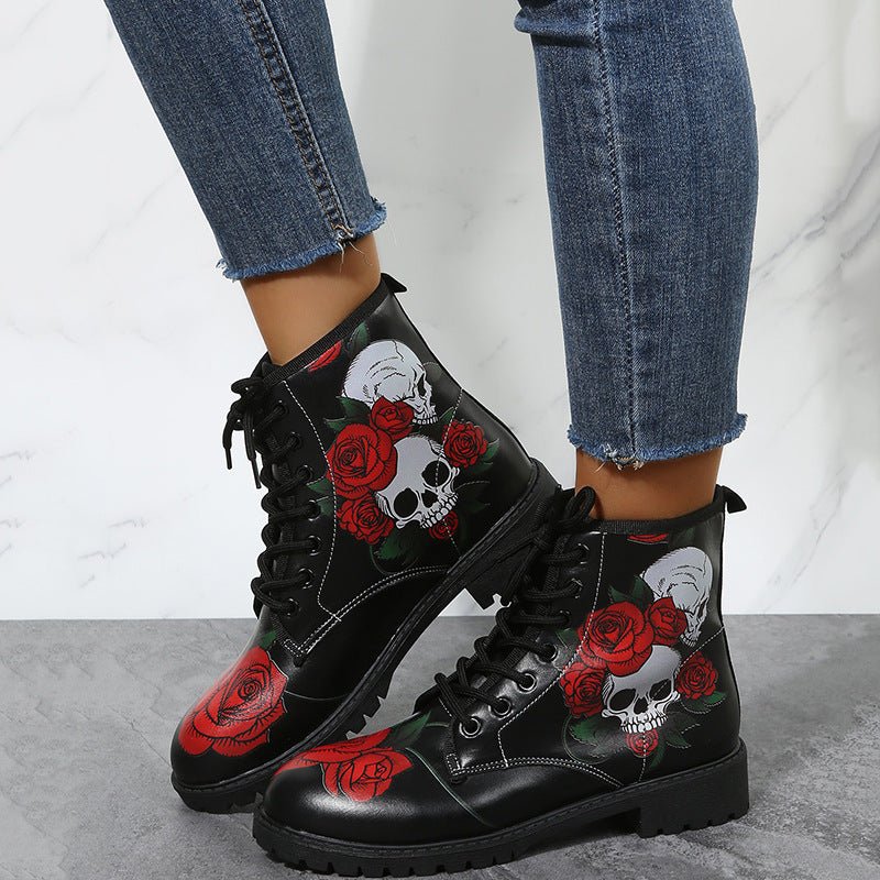 Pair of black high-top lace-up workwear boots featuring skull and red rose print by Ancient Energy