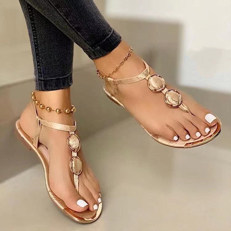 Women's Ancient Energy gold flat thong sandals with circular medallions and ankle strap