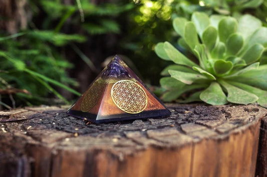 Ancient Energy Flower of Life Copper Orgone Pyramid with Amethyst crystal, detailed design, and vibrant purple gemstone accents.