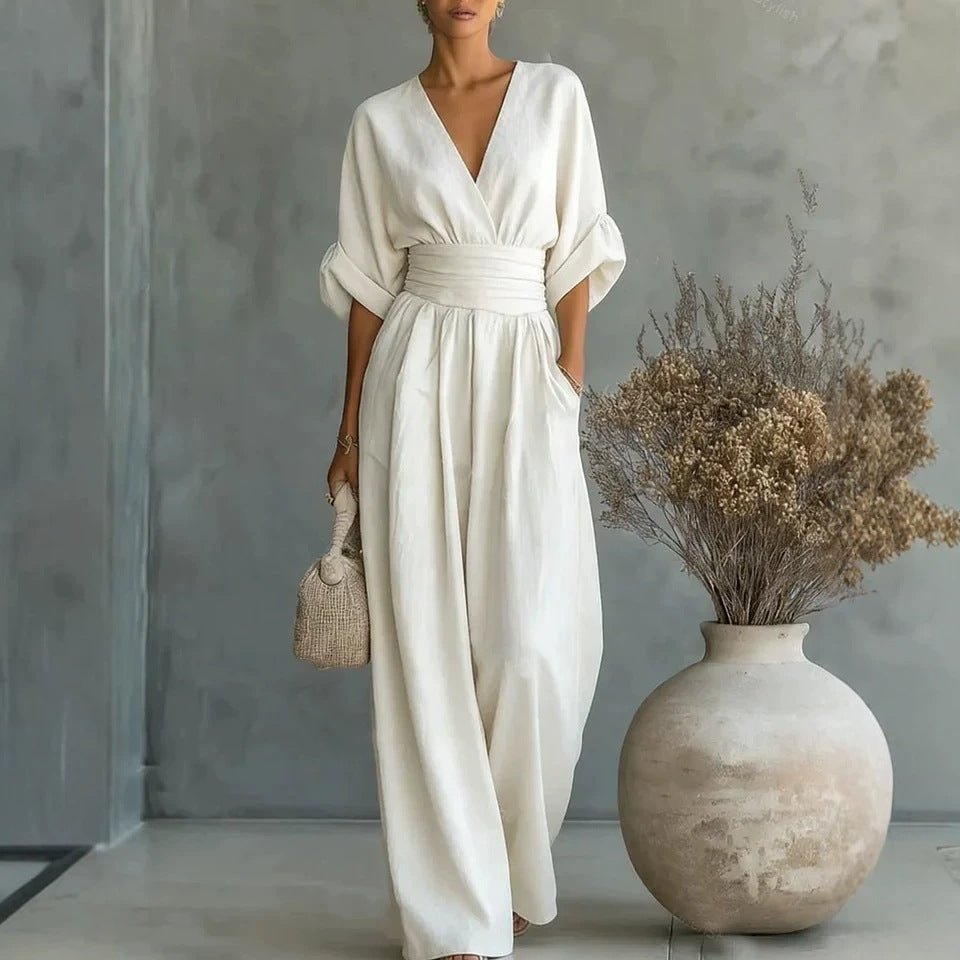 White summer short-sleeved jumpsuit with V-neck, wide-leg pants, and a cinched waist belt.