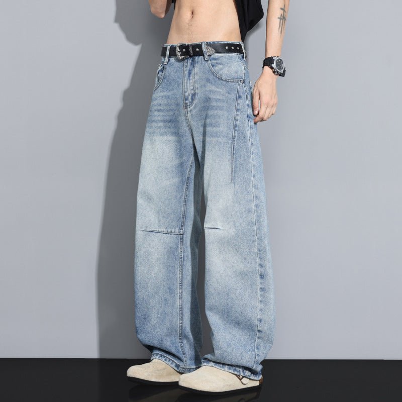 Men's denim jeans by Ancient Energy in light-wash, wide-leg fit with a black studded belt.