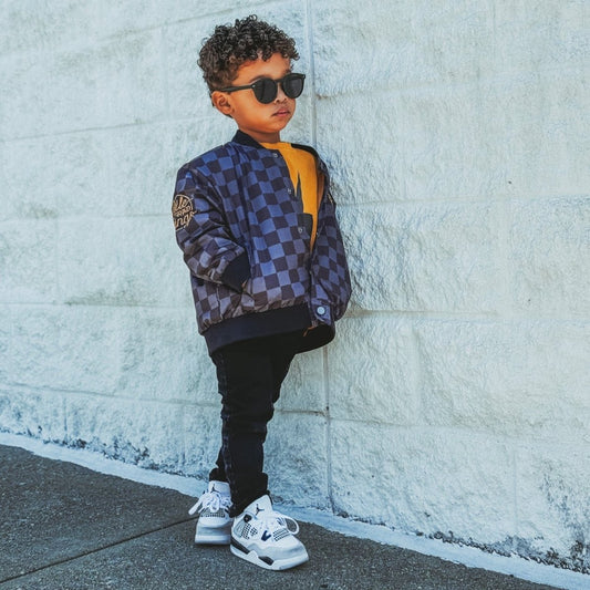 Kids waterproof letterman jacket with checkered pattern by Little Rad Things, featuring a colorful and stylish design for children.