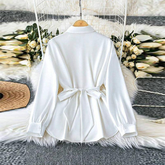 Women's solid color blouse with lapel collar, button-down front, adjustable metal waist belt, loose fit, suitable for casual or office wear.
