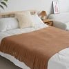 Knitted wool throw blanket with tassels by MANDOTOS INTERNATIONAL, cozy home decor and travel accessory in warm, soft fabric.