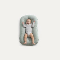 Baby nest bed in cotton, sage green, portable travel cradle with cushion.