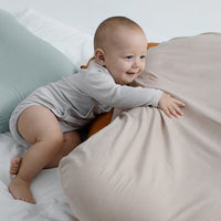 Baby nest bed cushion in beige cotton with orange edge; portable cradle for newborns