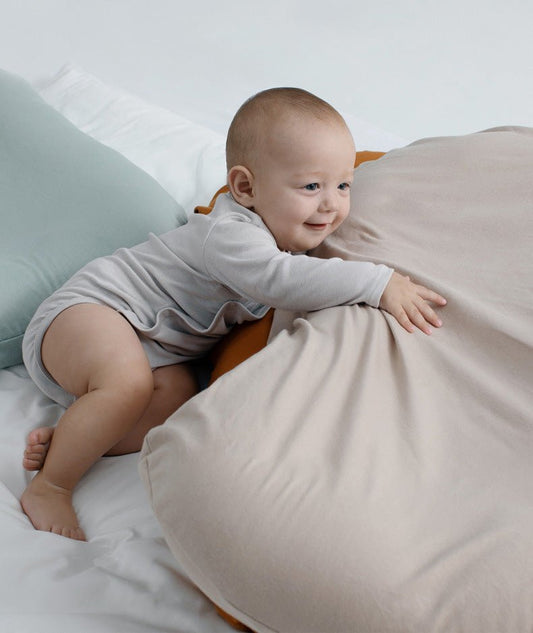 Baby nest bed cushion in beige cotton with orange edge; portable cradle for newborns