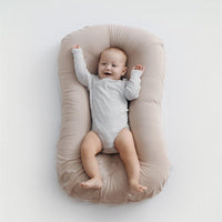 Baby nest bed in beige cotton, portable newborn travel cradle with cushioned sides
