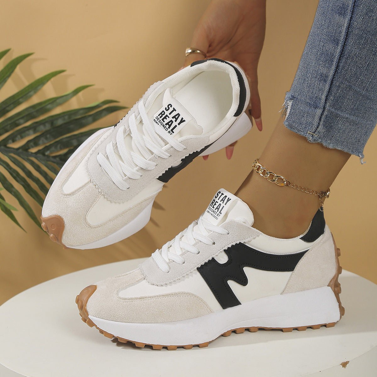 Womens chunky-soled lace-up sneakers by Ancient Energy, white upper with beige suede overlays and black side stripe.