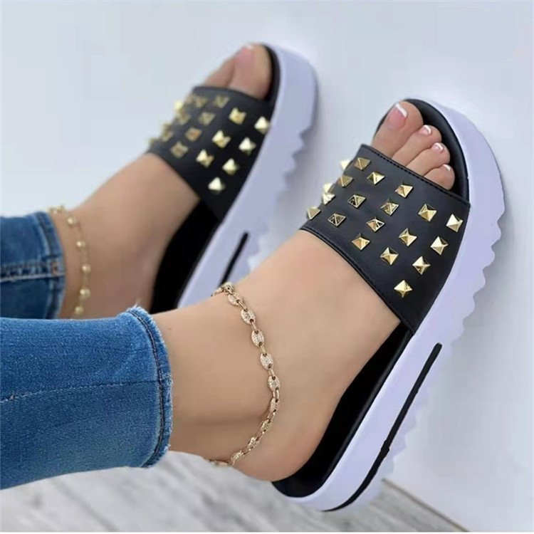 Women's Ancient Energy rivet wedge flip-flops with black studded strap and white platform sole.