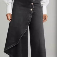 Unique straight-leg pants by Ancient Energy in black faux denim with asymmetric wrap hem and front button row.