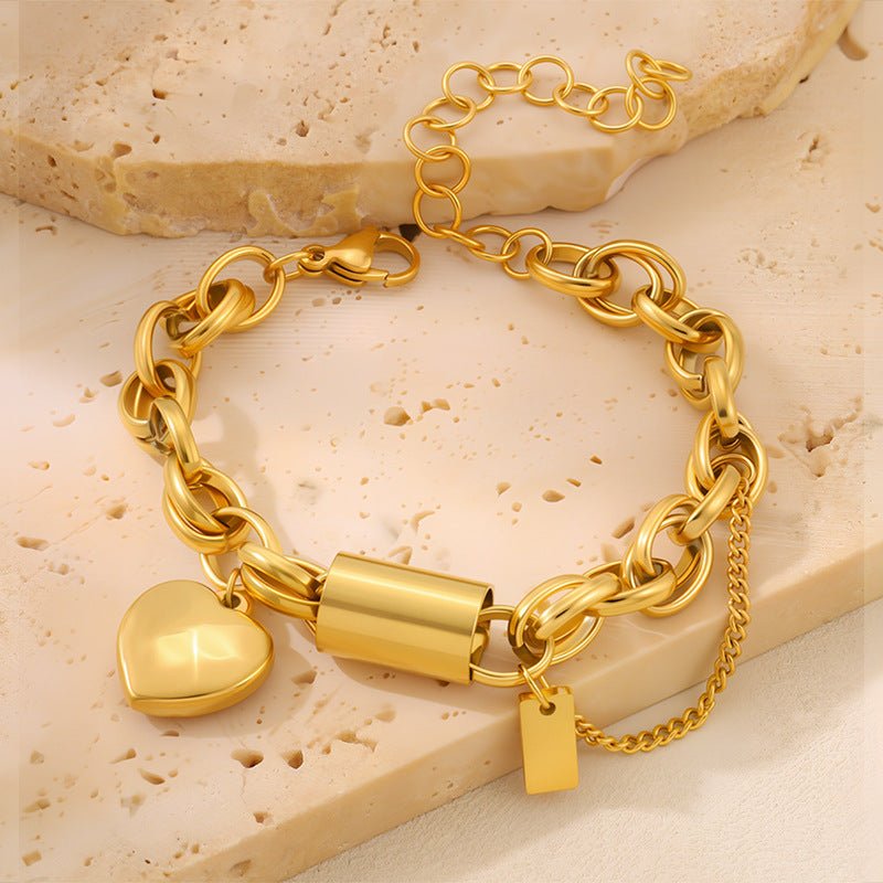 Versatile Titanium Bracelet With A Heart-shaped Pendant in gold-tone metal, with chunky linked chain and clasp.