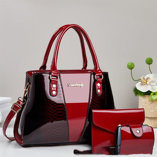 Large-capacity snakeskin-pattern tote bag with red glossy finish; includes matching wallet and cardholder.