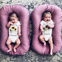 Two pink baby nest beds for newborns; portable cotton travel cradles.