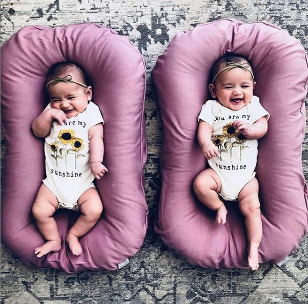 Two pink baby nest beds for newborns; portable cotton travel cradles.