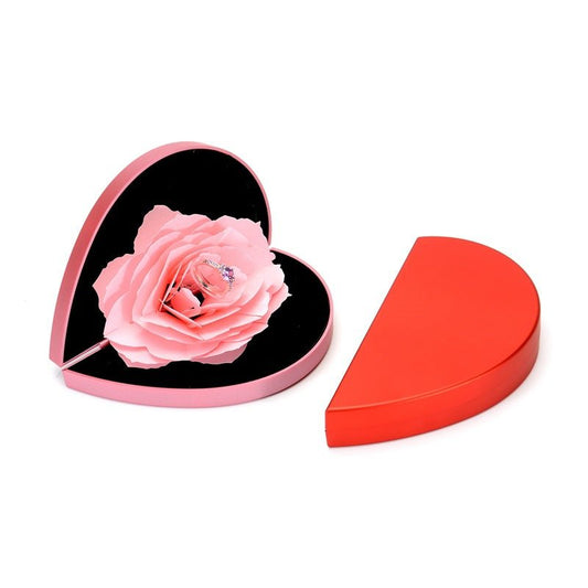 Two-piece heart-shaped pink jewelry box with pink rose and rotating ring inside; red outer lid shown