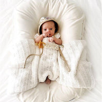 Ancient Energy baby nest bed for newborns: cream cotton travel crib with hood and knitted blanket.