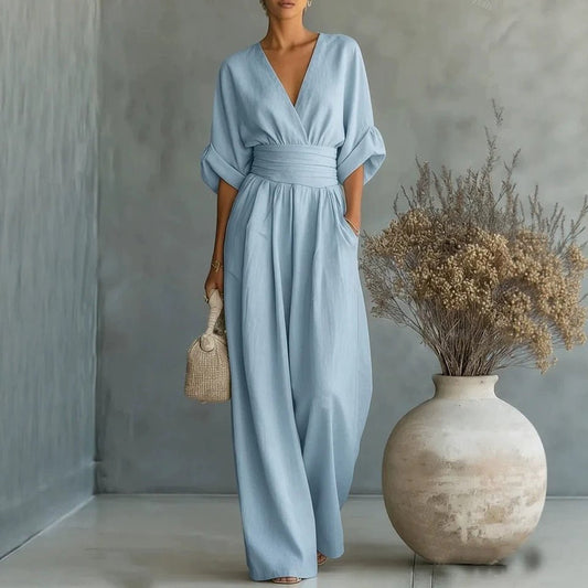 Summer short-sleeved jumpsuit in light blue with V-neck, wrapped waist, and wide-leg pants.