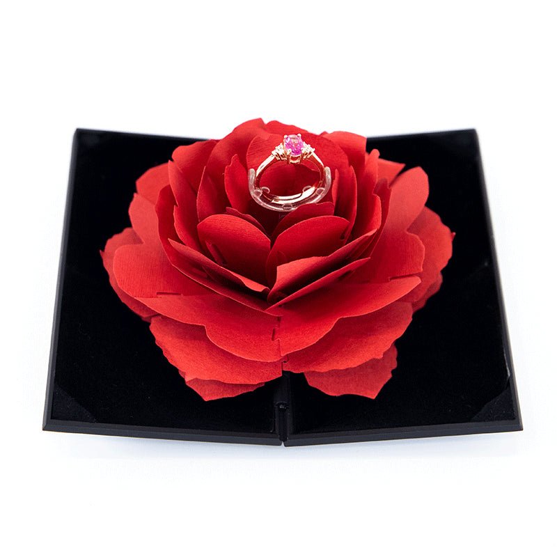 3D Love Box heart-shaped rose rotating ring box with pink gemstone ring on red petals in black presentation box