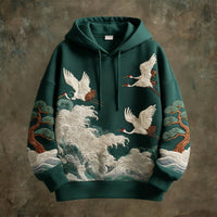 Hoodie by Ancient Energy in forest green with embroidered cranes, waves and pines.