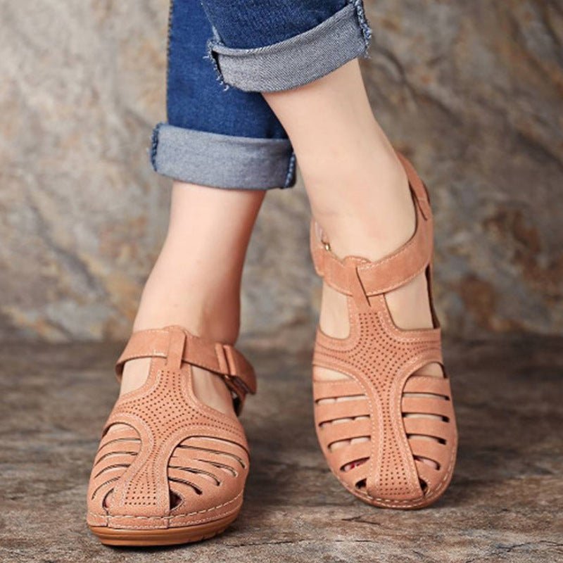 Pair of women's tan retro wedge sandals with round toe and perforated cutouts.