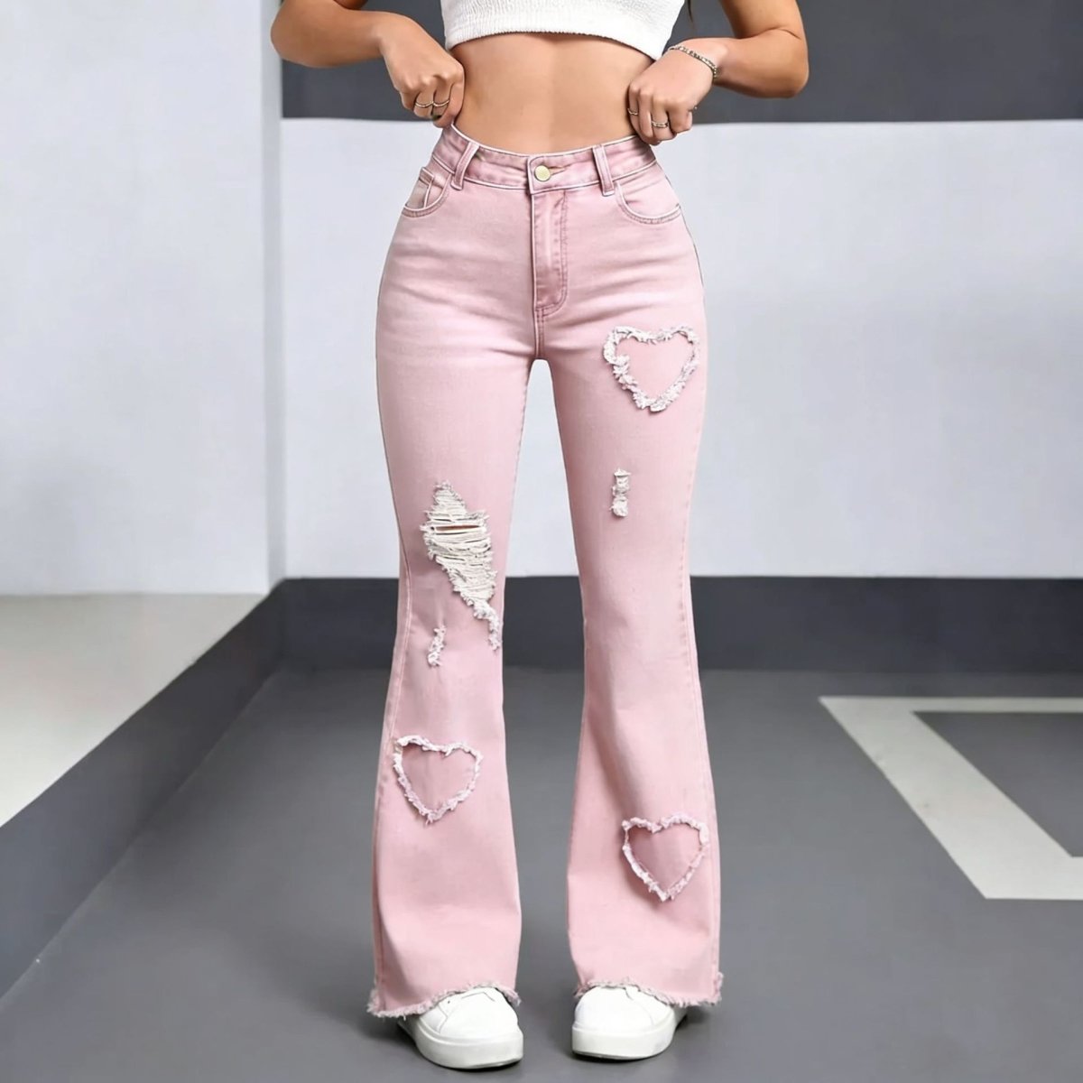 Pink distressed denim jeans for women with heart patches and frayed hems by Ancient Energy.