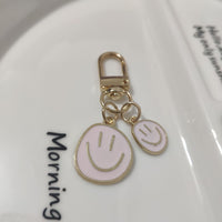 Cross-border e-commerce alloy color dripping smiley face keychain electroplated gold irregular expression bag pendant accessories