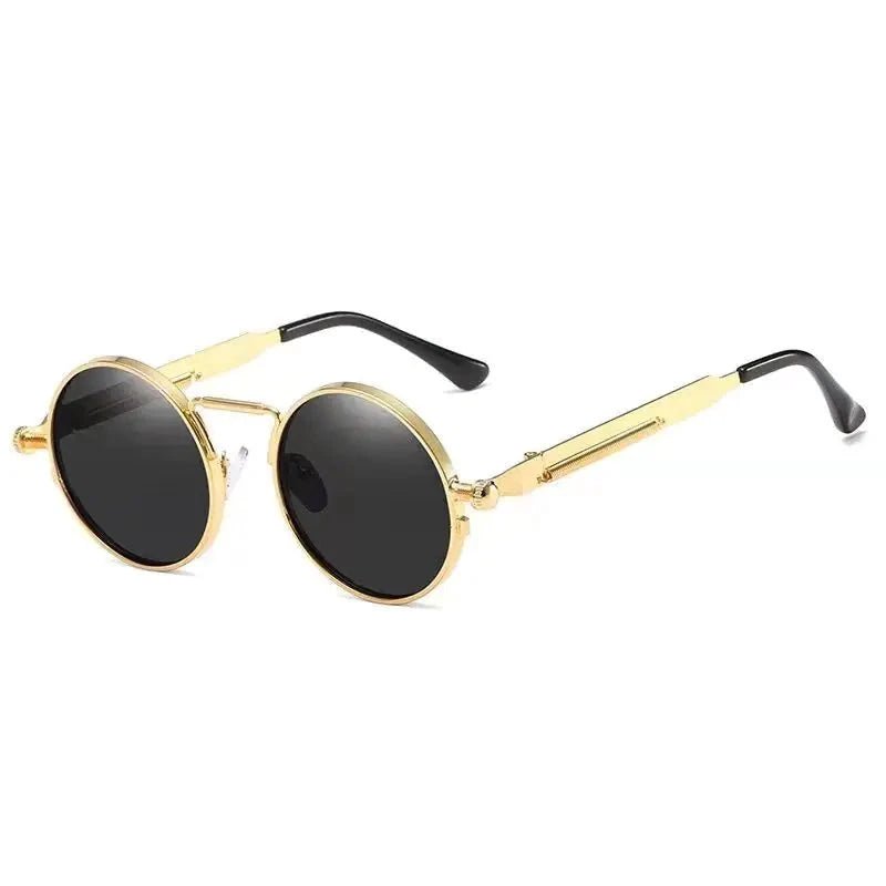 Gold-tone circular steampunk sunglasses with clear nose pads, black lenses, and black-tipped gold temples.