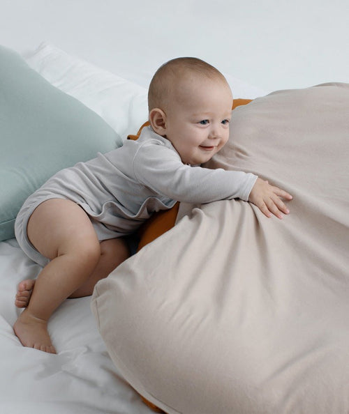 Baby nest bed cushion in beige cotton with orange edge; portable cradle for newborns