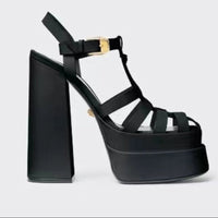 Black platform sandals by Ancient Energy with chunky heel, strappy fish-mouth design and gold buckle.