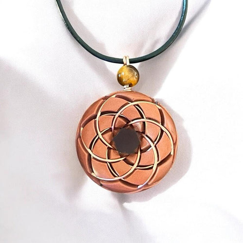 Torus vortex pendant necklace featuring copper orgonite, Rodin coil design, and tiger's eye gemstone by Ancient Energy.