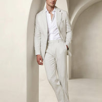 Men's beige suit with white shirt and brown loafers; tailored blazer and trousers.