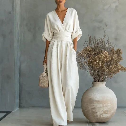 White summer short-sleeved jumpsuit with V-neck, wide-leg pants, and a cinched waist belt.