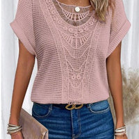 Pink hollow-out knit top with intricate lace neckline and short sleeves