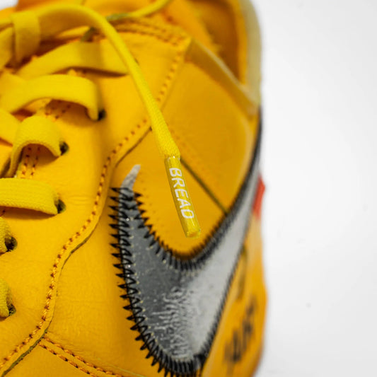 Yellow elastic shoelace by Bread labeled Corona Yellow with stretchable material and round design for casual footwear.