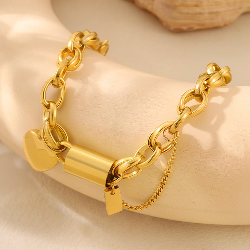 Versatile titanium bracelet with heart pendant, gold-tone chunky chain and lock charm