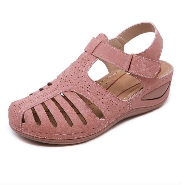 Women's pink retro wedge sandal with round toe, cutout uppers, and adjustable ankle strap