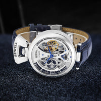 Mens skeleton watch with blue leather strap and silver case; Bewell branding visible.