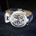 Mens skeleton watch with blue leather strap and silver case; Bewell branding visible.