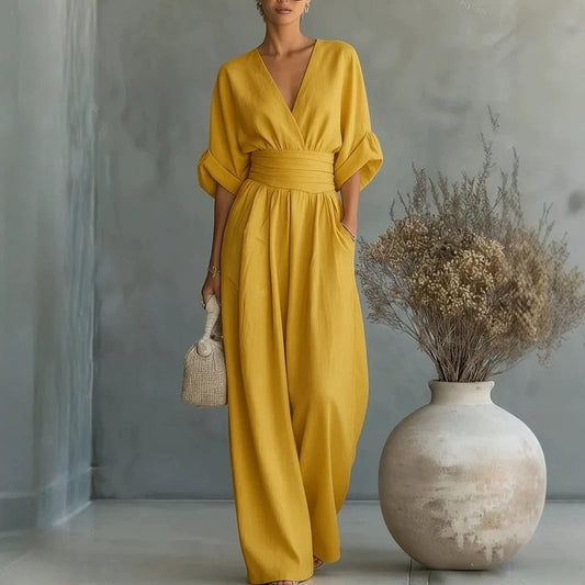 Jumpsuit by Ancient Energy; yellow mustard short-sleeve V-neck with wide-leg pants and belted waist.