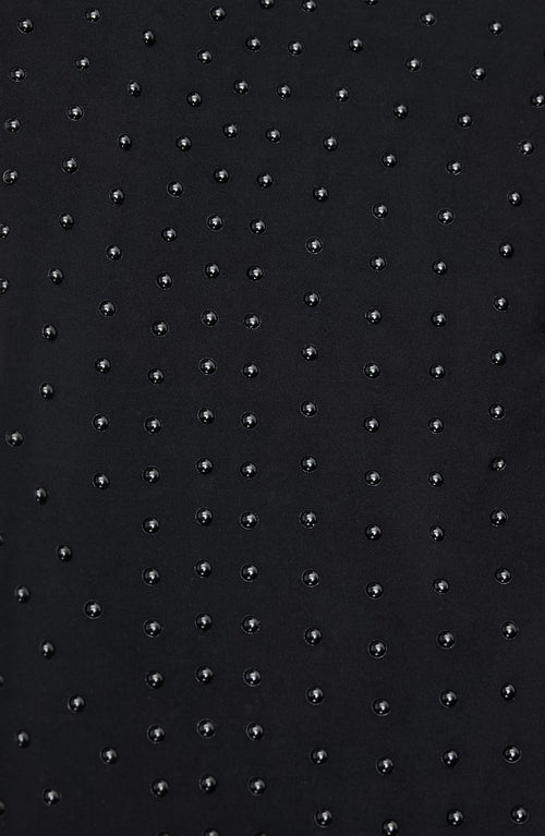 Close-up of Elastique Athletics Iconic 3/4 Sleeve MicroPerle black top showing detailed microperle fabric and sleeve design.