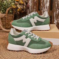 Pair of women's chunky-soled sneakers by Ancient Energy in green and white, lace-up casual shoes.