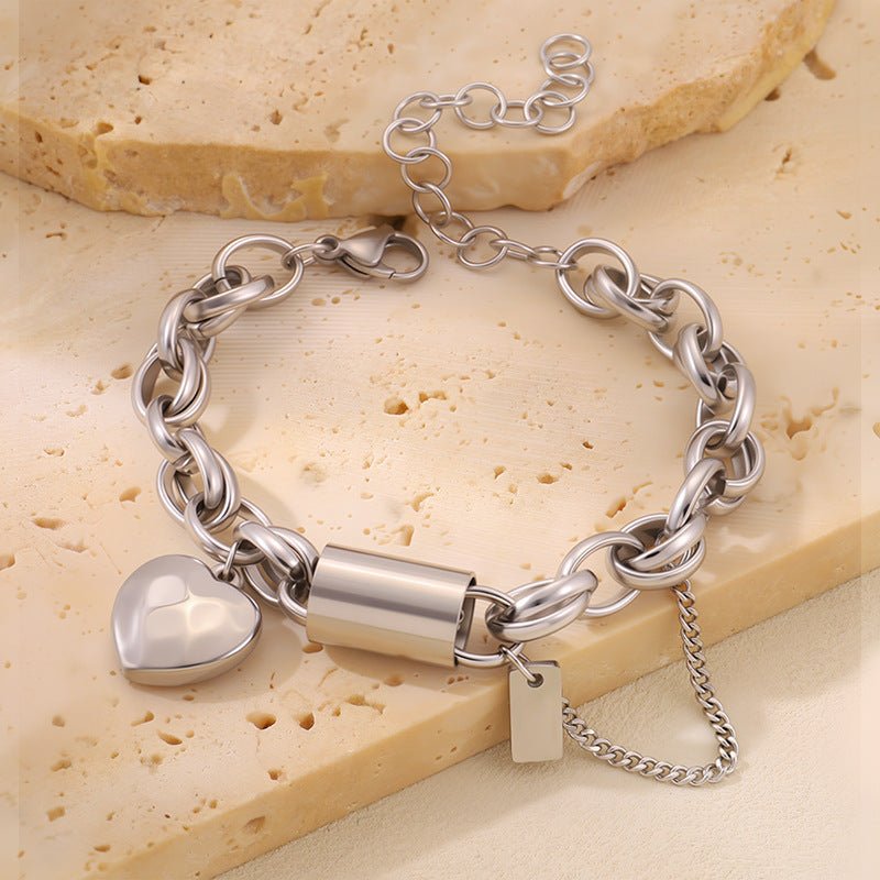 Versatile titanium bracelet with heart-shaped pendant, chunky silver chain, and adjustable extension with padlock clasp.
