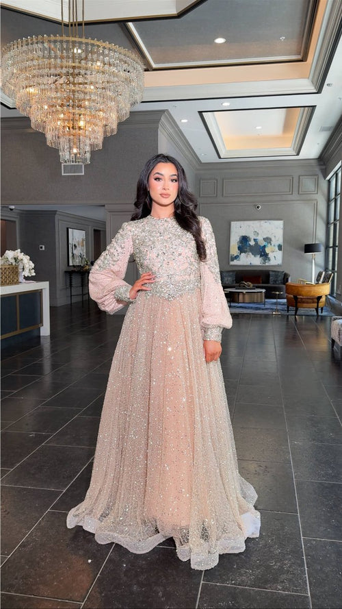 Iyza Belaar Bashira long sleeve embellished sequin modest ball gown, elegant evening dress with intricate detail and flowing fabric.
