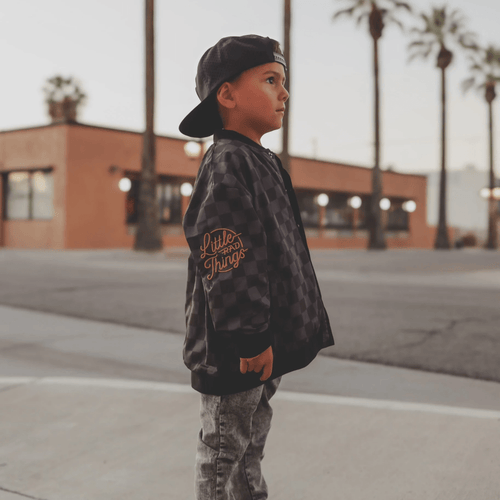 Kids waterproof letterman jacket by Little Rad Things featuring a checkers pattern and sporty style.
