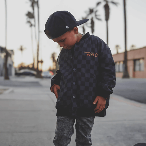 Kids waterproof letterman jacket by Little Rad Things with checkered pattern, featuring a durable, stylish design suitable for boys and girls.