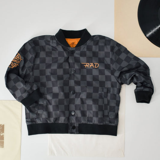 Kids waterproof letterman jacket with checkered pattern by Little Rad Things, featuring a stylish and durable outer layer for outdoor wear.