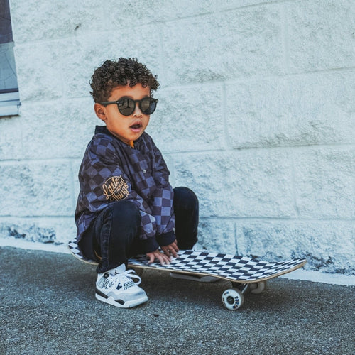 Kids waterproof letterman jacket by Little Rad Things featuring a checkers pattern, durable and stylish for outdoor wear.